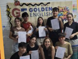 Alumnado y docente celebrando exámenes con diplomas frente a un banner institucional.
